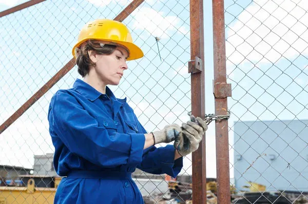 Techniker mit Schutzhelm arbeitet an einem Tor